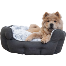 Stor lysebrun hundehvalp ligger i en mørkegrå hundeseng